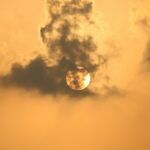 the sun is setting behind the clouds in the sky