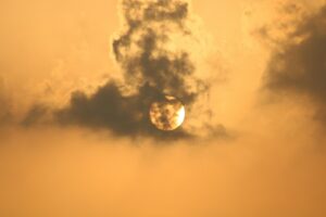 the sun is setting behind the clouds in the sky